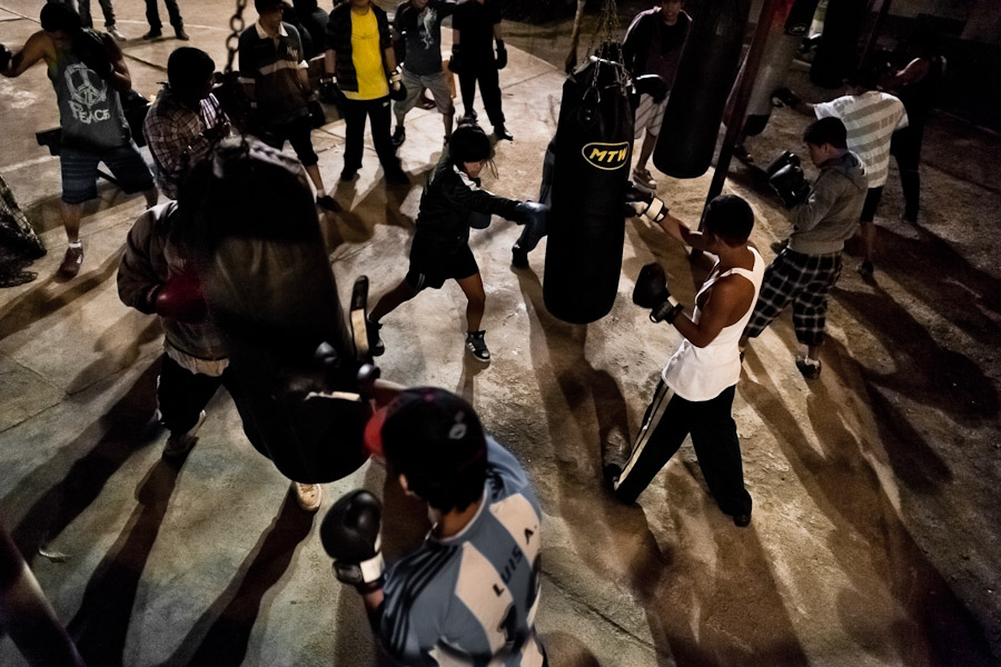 Peruvian youths practice with punching bags during the evening at the Boxeo VMT boxing club in an outdoor gym in Lima, Peru.