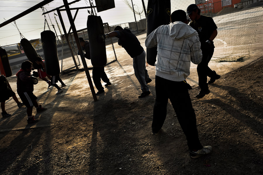 Peruvian youths practice with punching bags at the Boxeo VMT boxing club in an outdoor gym in Lima.