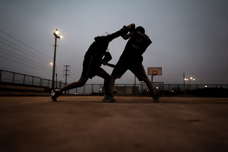 Peruvian youths practice boxing sparring during the dusk at the Boxeo VMT boxing club in an outdoor gym in Lima, Peru.