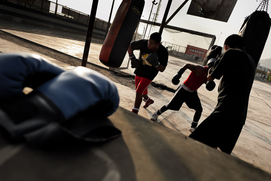 Peruvian youths practice with punching bags at the Boxeo VMT boxing club in an outdoor gym in Lima.