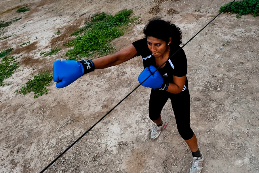 A Peruvian woman practices punching and movement while training in the outdoor boxing school at the Telmo Carbajo stadium in Callao, Peru.
