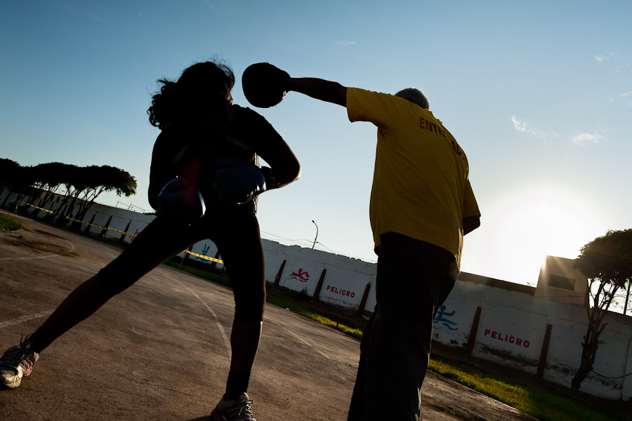 A Peruvian woman practices sparring with her coach in the outdoor boxing school at the Telmo Carbajo stadium in Callao, Peru.