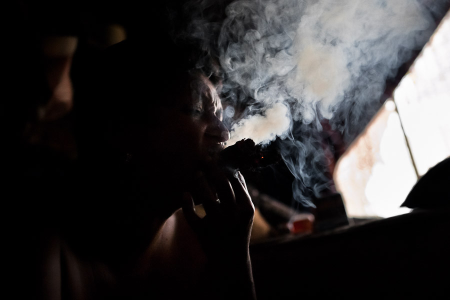 A Colombian woman puffs three cigars to devine the future from burn tobacco leaves in a shaman's house in Cali, Colombia.