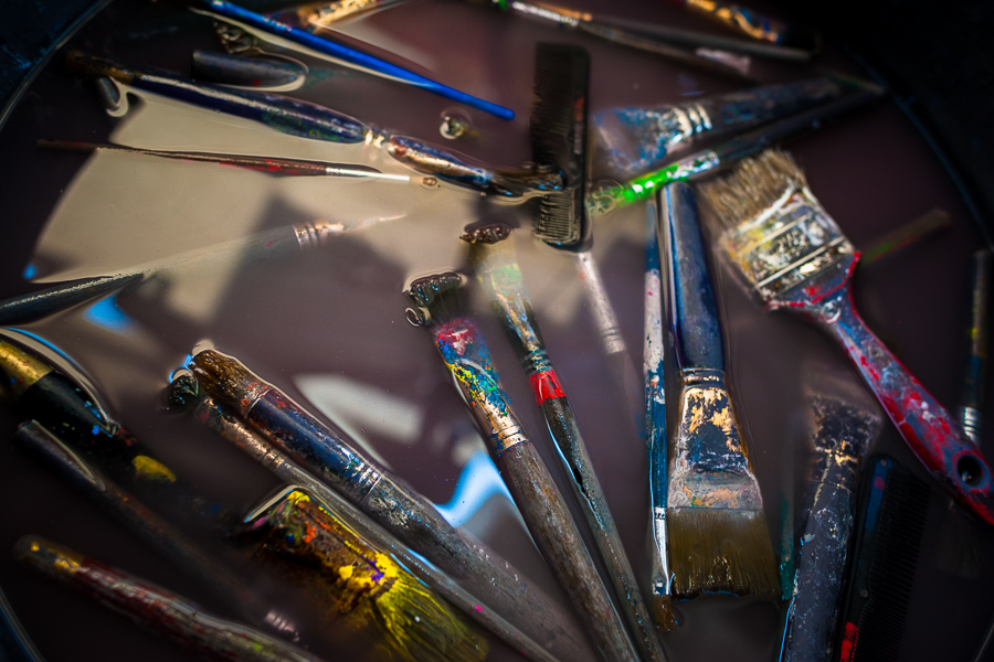 Painting brushes are seen floating in the rinse water basin in the sign painting workshop in Cartagena, Colombia.