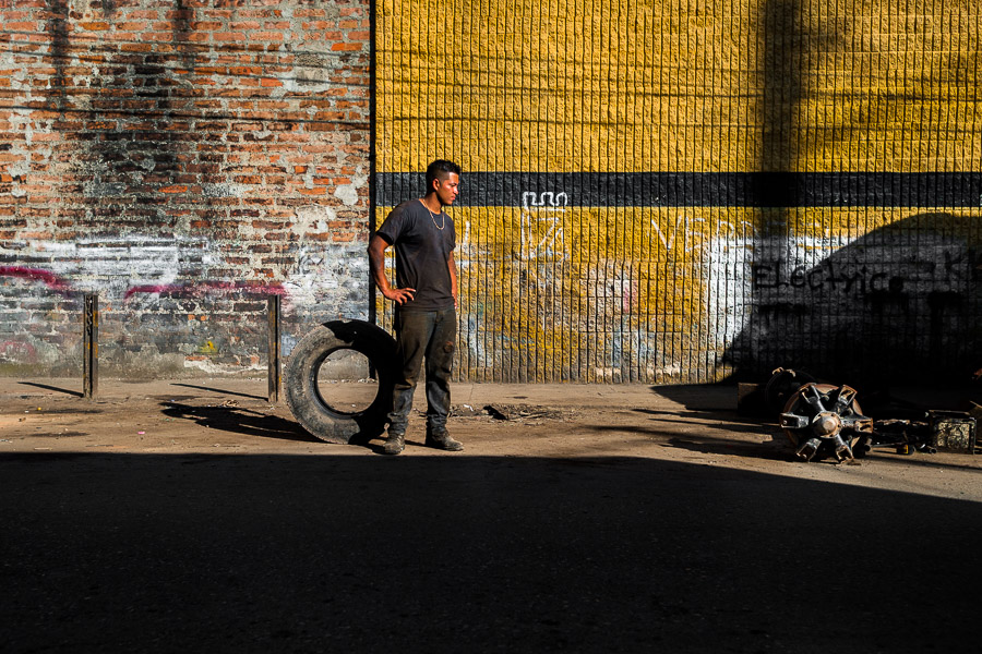 A Colombian wheel mechanic waits for the customers in the street of Barrio Triste, a car mechanics neighborhood in Medellín, Colombia.