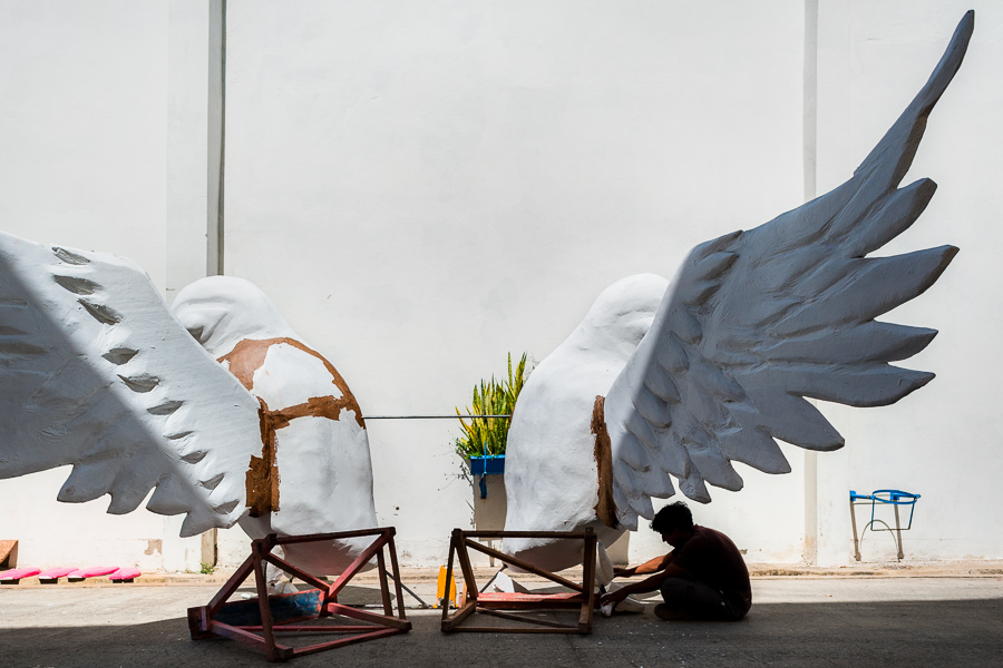 A Colombian artisan works on paper-mâché sculptures of parrots for an allegorical float outside the Carnival float workshop in Barranquilla, Colombia.