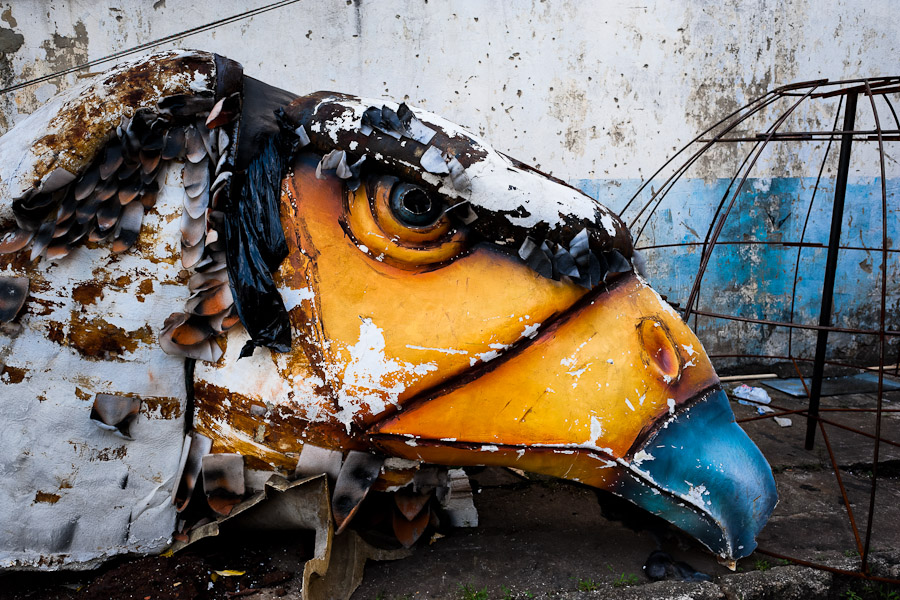 A damaged carnival sculpture of a bird abandoned on the work yard behind the Samba school workshops in Rio de Janeiro, Brazil.