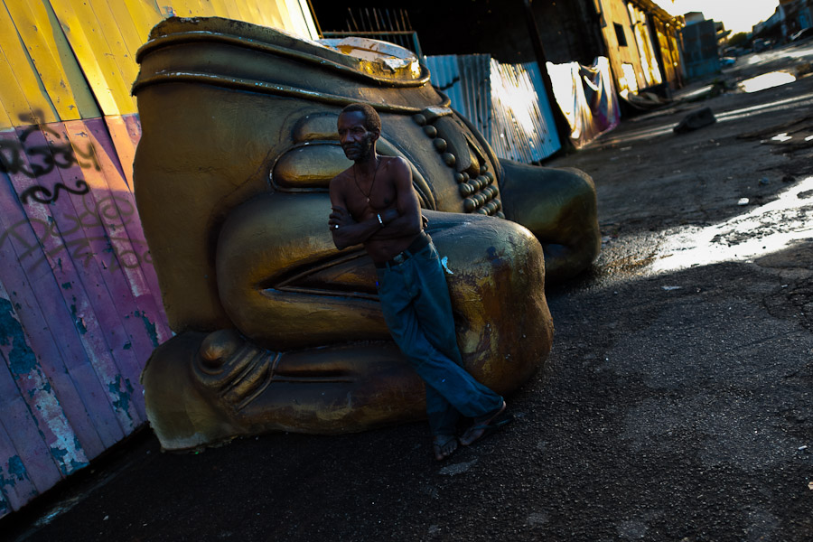 A Brazilian man rests on a damaged carnival sculpture outside the Samba school workshops in Rio de Janeiro, Brazil.