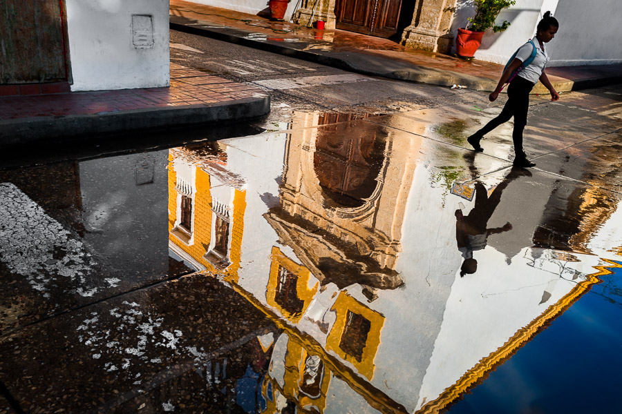 A Colombian girl walks to the school in front of Santo Toribio Church, located in the colonial walled city, during a sunny morning in Cartagena, Colombia.