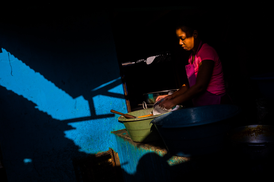 A young Afro-Colombian woman washes the dishes at the end of a twelve-hour shift in a street restaurant in the market of Bazurto, Cartagena, Colombia.
