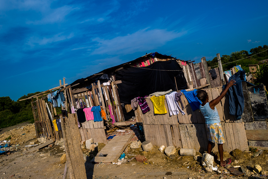 An Afro-Colombian woman hangs laundry to dry on a wooden fence outside her house in Olaya Herrera, a low social class neighborhood in Cartagena, Colombia.