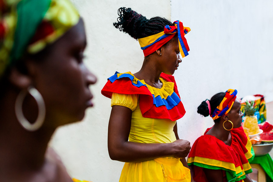 Afro-Colombian women, dressed in the traditional ‘palenquera’ costume, sell fruits on the street of Cartagena, Colombia.