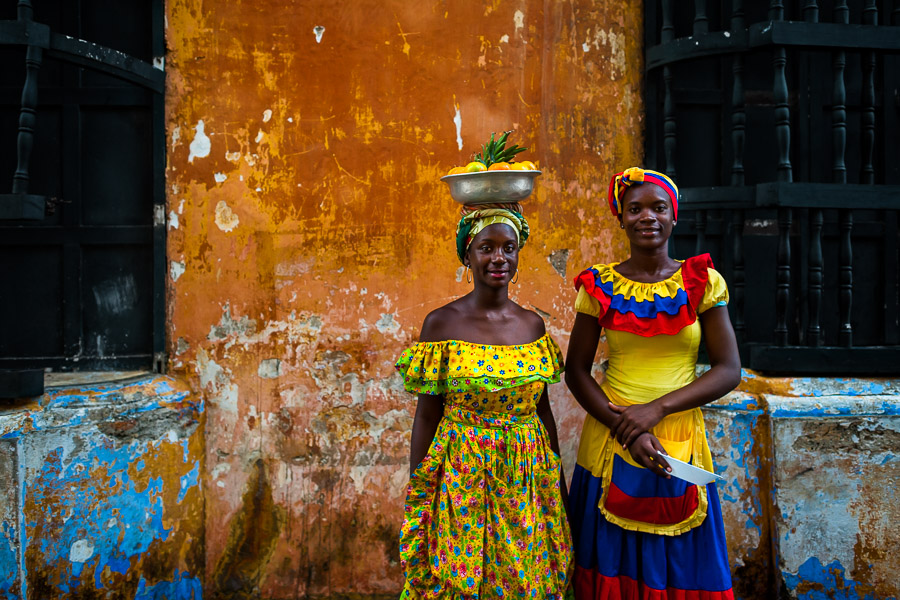 Afro-Colombian girls, dressed in the traditional ‘palenquera’ costume, pose for a picture in front of a colonial house in walled city of Cartagena, Colombia.