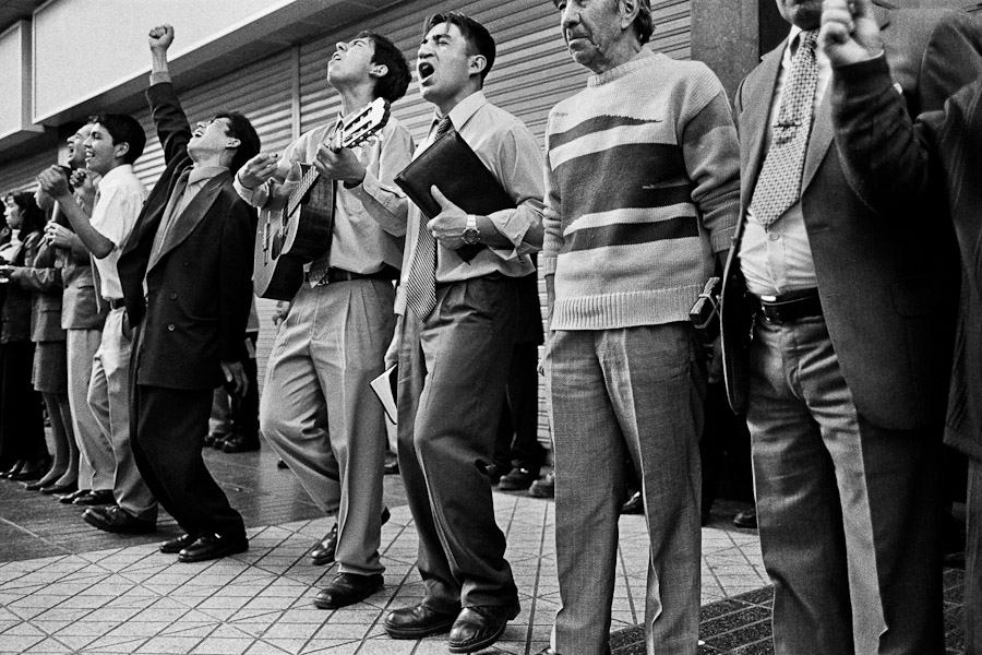 Catholic street preachers, experiencing a religious trance, sing and play guitar on the street of Santiago de Chile, Chile.