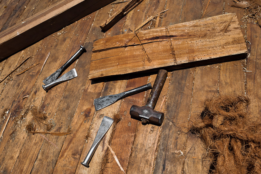 Caulking irons, caulking mallet and hemp fiber (oakum) are seen on the board of a traditional wooden fishing vessel in an artisanal shipyard on the beach in Manta, Ecuador.