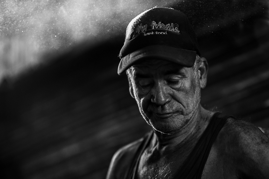 A Colombian charcoal worker fills plastic bags with charcoal in the street market in Barranquilla, Colombia.