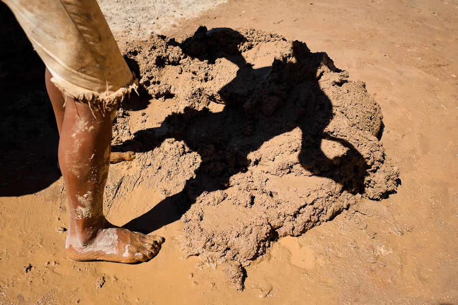 Moisés, a thirteen-year-old Salvadoran boy, shovels wet clay at a brick factory in Istahua, El Salvador.