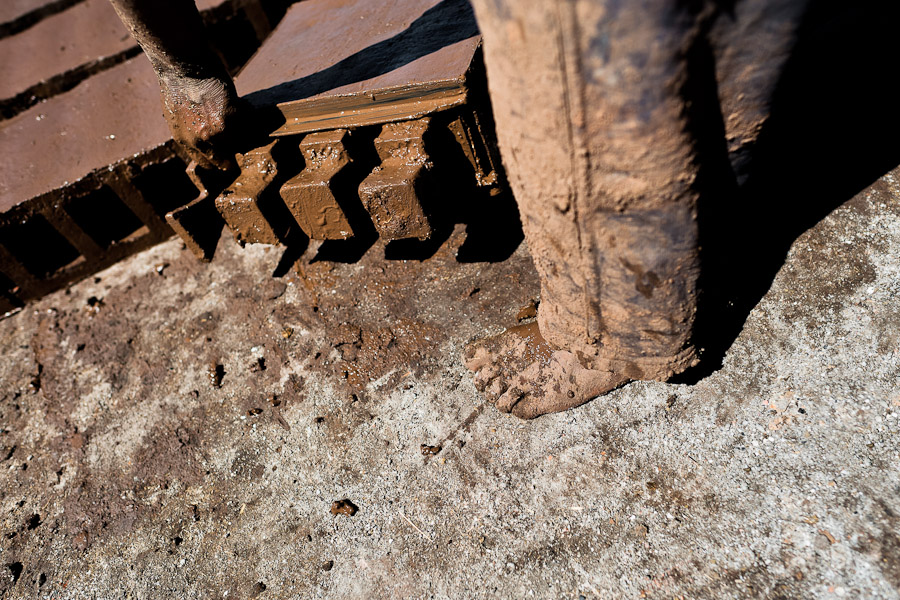 A Peruvian boy, working barefoot, molds bricks of clay at a brick factory in the outskirts of Puno, Peru.