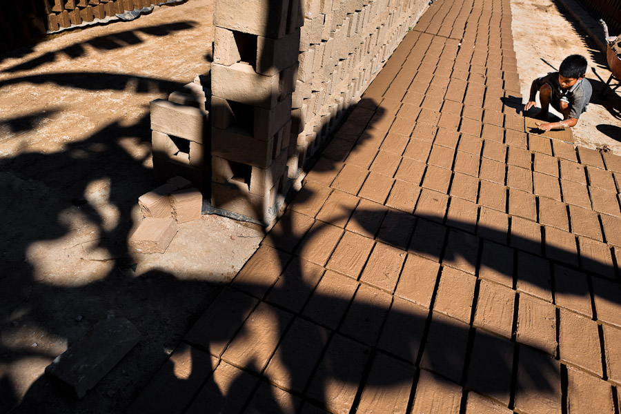 Brian, a ten-year-old Salvadoran boy, molds bricks of clay at a brick factory in Istahua, El Salvador.