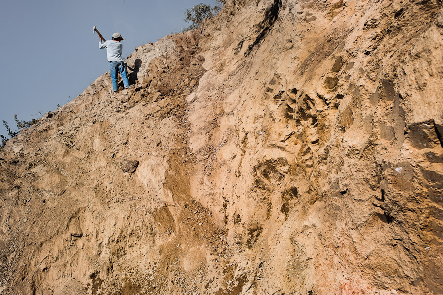 A Salvadoran boy digs clay for brick making on the hill behind a brick factory in Istahua, El Salvador.