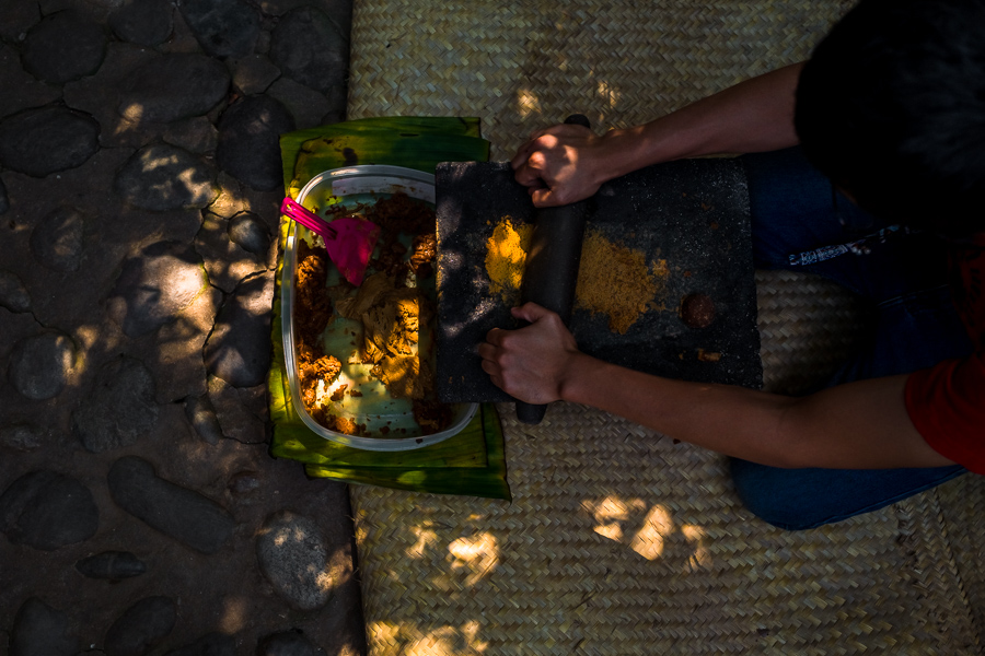A Mexican man grinds panela (unrefined cane sugar) on a metate (a mealing stone) in artisanal chocolate manufacture in Xochistlahuaca, Guerrero, Mexico.