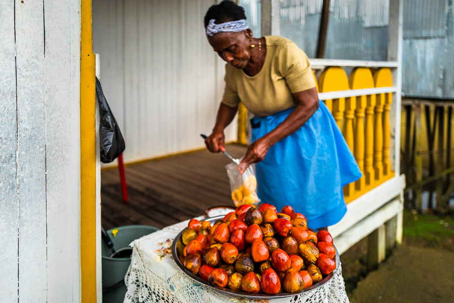 An Afro-Colombian woman salts freshly cooked chontaduro (peach palm) fruits on the porch of her house in Quibdó, Chocó, Colombia.