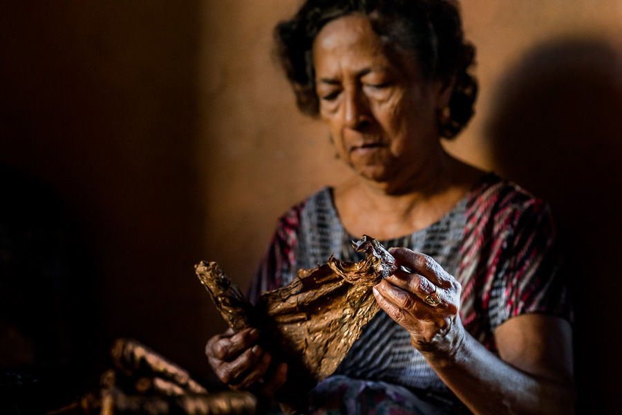 Laura Peña, a 67-years-old Salvadoran woman, rolls tobacco leaves to make handmade cigars in her house in Suchitoto, El Salvador.