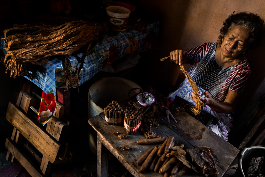 Laura Peña, a 67-years-old Salvadoran woman, selects a tobacco leaf to make handmade cigars in her house in Suchitoto, El Salvador.