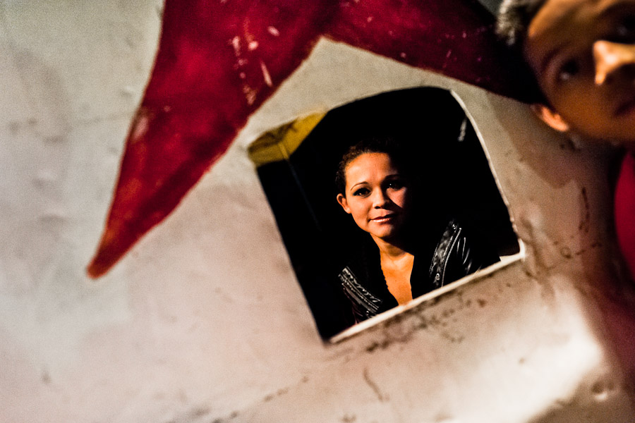 Bianca Rocio, a Salvadorean dancer, seen through a ticket office at the Circo Brasilia, a family run circus travelling in Central America.