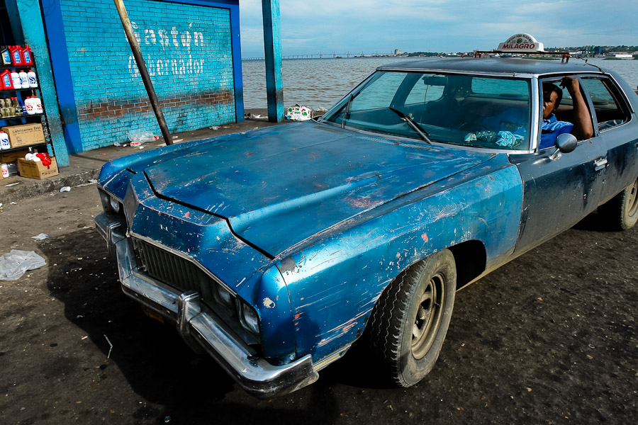 A scratched American classic car from 1970s, used as a shared taxi, waiting on the stand in Maracaibo, Venezuela.