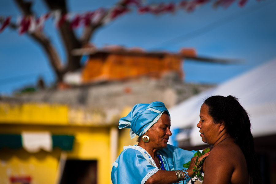 A Baiana woman performs a cleansing ritual, using the herbs for purification, in front of the St. Lazarus church in Salvador, Bahia.