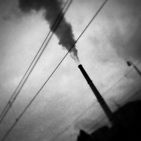A smoking chimney of the Prunéřov I coal-fired power plant seen from the train passing through the industrial area in the north of the Czech Republic.