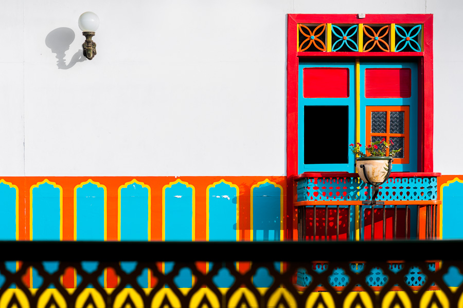 A brightly painted wooden balcony is seen in the first floor of a colonial house in Jardín, a village in the coffee region of Colombia.