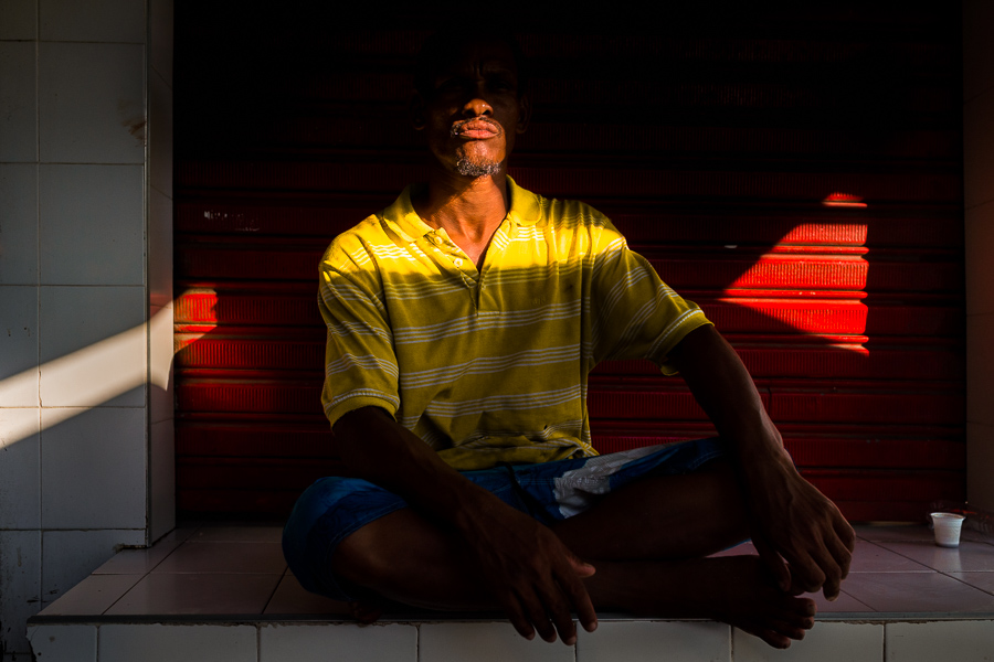 An Afro-Colombian worker drinks a small “tinto” (black coffee) while taking a rest in the shadow at the market of Bazurto in Cartagena, Colombia.