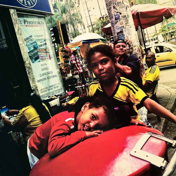 Young Colombian girls, wearing the national football team t-shirt, play children games on the street in Cali, Colombia.