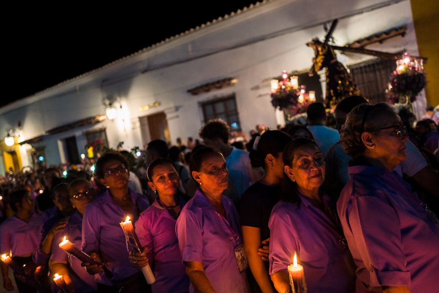 Female Catholic devotees, members of a religious brotherhood, carry lit candles during the Holy Week procession in Mompox, Colombia.