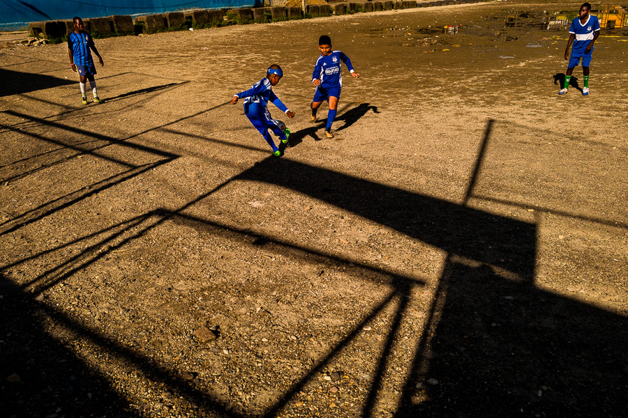 Young Afro-Colombian boys play football during the training session on a dirt playing field in Quibdó, Chocó, Colombia.