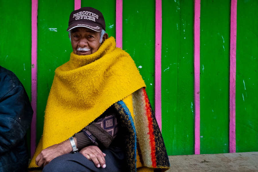 A Colombian man, wearing poncho and the Narcotics Officer cap, sits in front of his house in the slum of Ciudad Bolívar, Bogota.