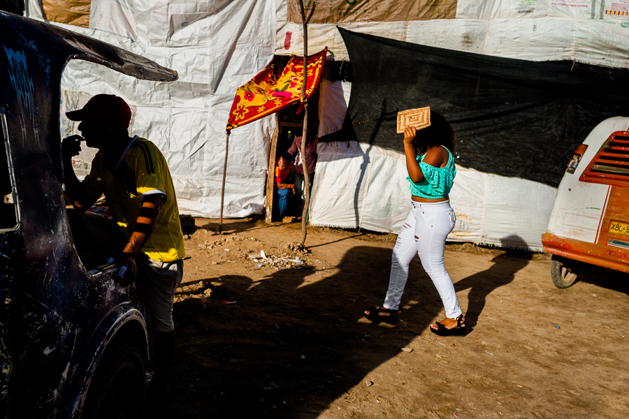A Colombian girl, covering herself from the sun, walks around the arena of Corralejas, a rural bullfighting festival held in Soplaviento, Colombia.