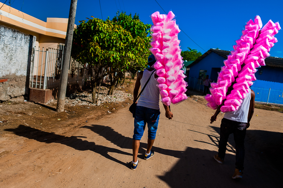 Colombian street vendors, carrying cotton candy bags for sale, walk towards the arena of Corralejas, a rural bullfighting festival held in Soplaviento, Colombia.