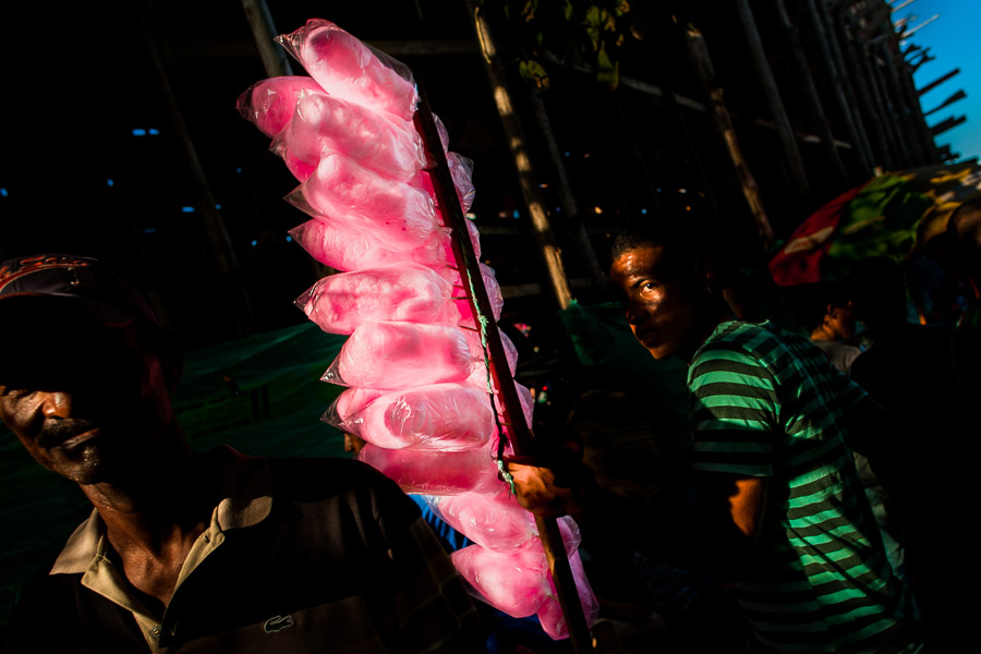 A Colombian street vendor, holding cotton candy bags for sale, walks around the arena of Corralejas, a bullfighting festival in Soplaviento, Colombia.