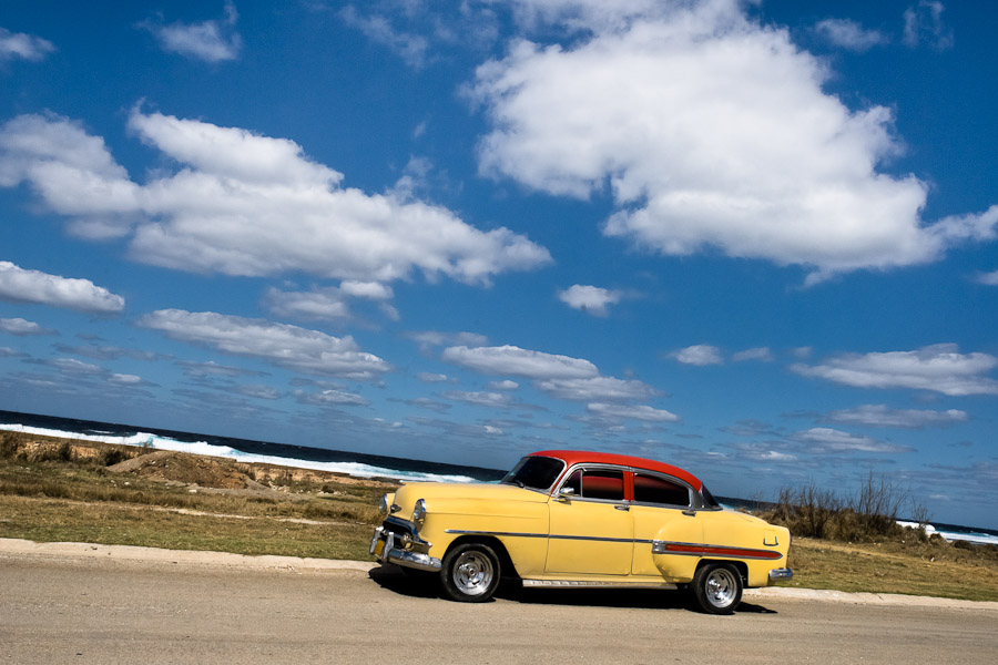 An American classic car is seen passing on the dusty road along the sea in Alamar, a public housing complex in the Eastern Havana, Cuba.