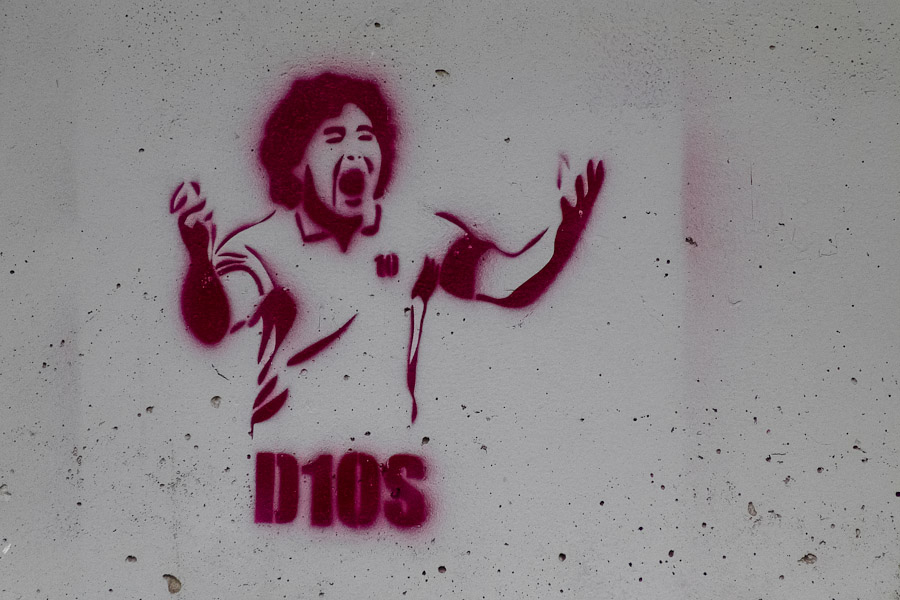 A spray and stencil artwork, depicting legendary Argentine football player Diego Maradona (D10S), appears on the street of San Jose, Costa Rica.