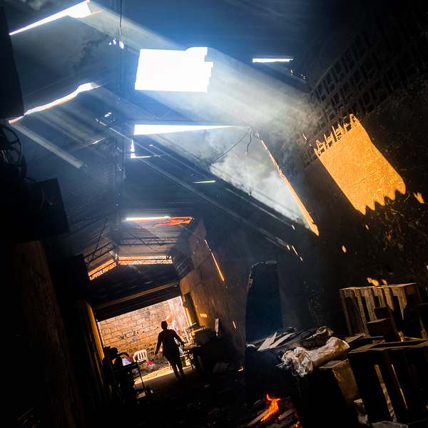 A Colombian woman walks down a dark corridor in the market of Bazurto in Cartagena, Colombia.