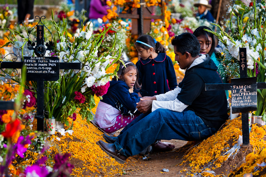 A Mexican family gathers at the flower-decorated grave to honor the deceased relatives during the Day of the Dead festivities in Tzurumútaro, Michoacán, Mexico.