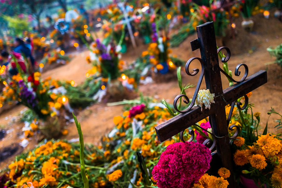 A black cross is seen at a flower-decorated grave during the Day of the Dead festivities in Oaxaca, Mexico.