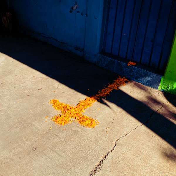 A cross made of cempasúchil flowers is placed on the ground in front of a house during the Day of the Dead (Día de Muertos) celebrations in Tlapa de Comonfort, Mexico.