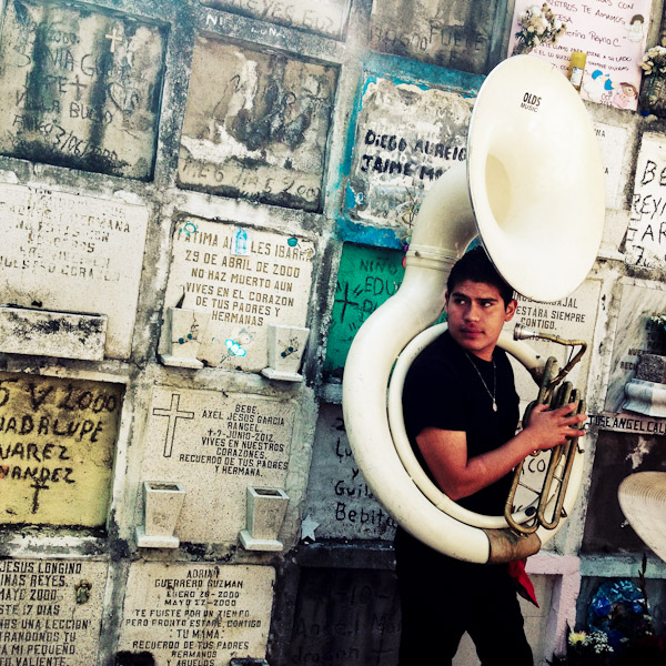 A young Mexican musician, holding a sousaphone, takes a part in the annual ceremony of Día de los Muertos (Day of the Dead) in the cemetery of Morelia, Michoacán, Mexico.