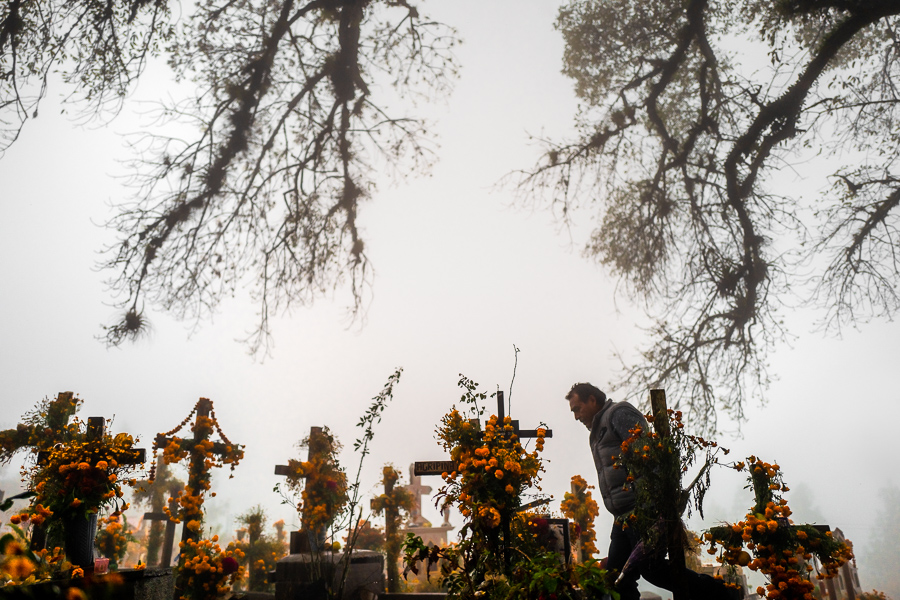 A Mexican man walks amongst the flower-decorated graves at a cemetery during the Day of the Dead celebrations in Ayutla, Mexico.