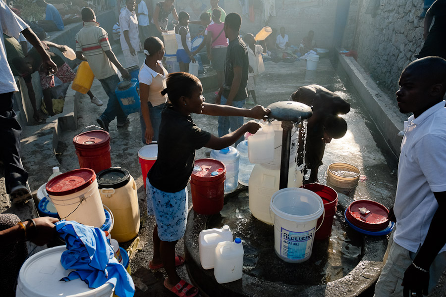 A Haitian girl fills plastic barrels with safe drinking water from a public water pump in Port-au-Prince, Haiti.